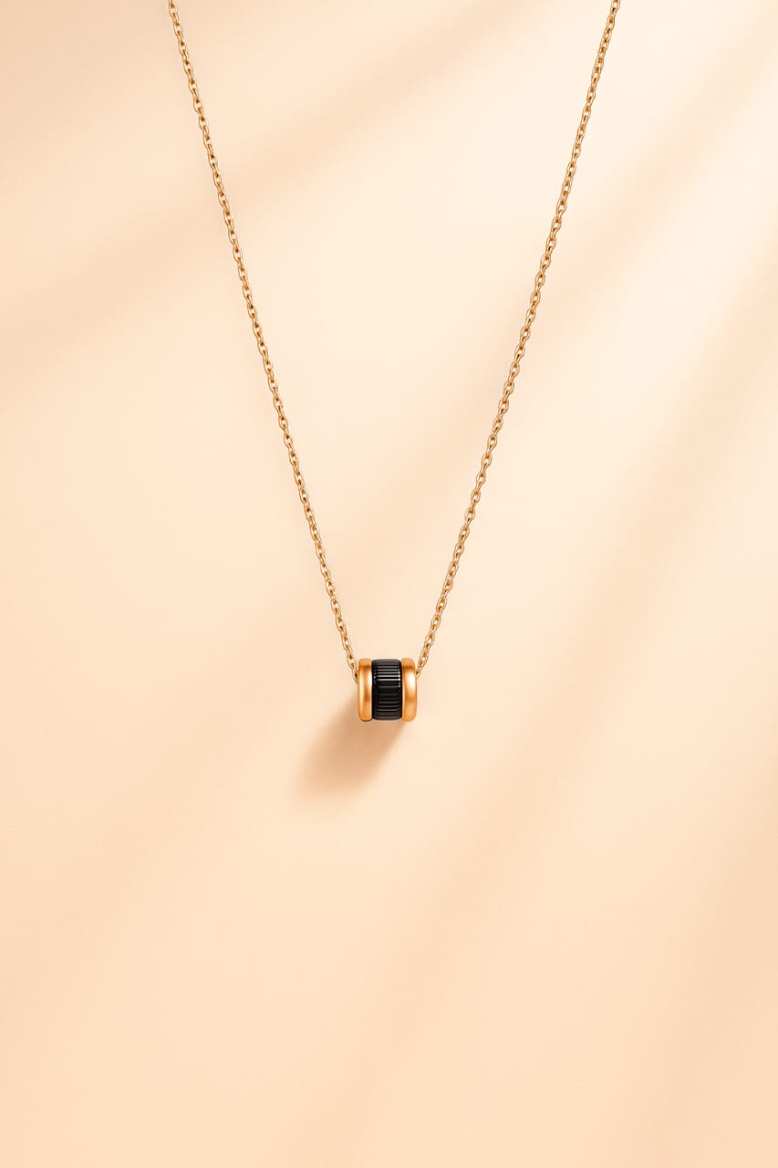 Elegant Gold-Tone Chain Necklace with Black Ribbed Barrel Pendant
